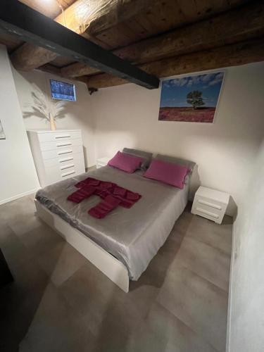a bedroom with a large bed with pink pillows at HEATHER'S HOME 110 Apt 400mt from Old Bridge in Bassano del Grappa