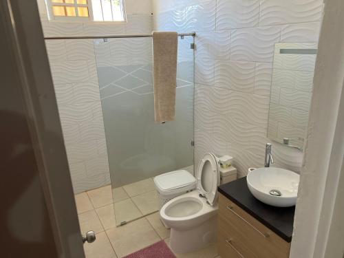 a bathroom with a toilet and a glass shower at Villa Caterina in Dajabón