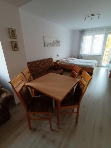 a living room with a table and chairs and a bed at Villa Marcela in Karpacz