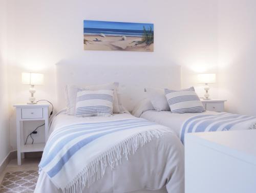 2 Betten in einem Schlafzimmer mit einem Bild vom Strand in der Unterkunft C(2) Precioso y cómodo departamento a metros del mar in Mar del Plata