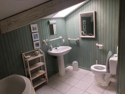 a bathroom with a sink and a toilet at Maison landaise moderne piscine chauffée spa in Lit-et-Mixe