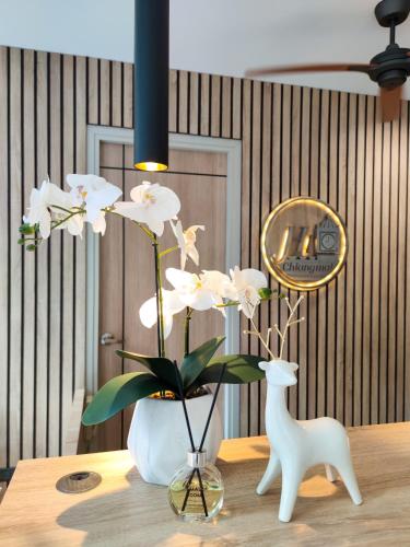 Un jarrón con flores blancas sobre una mesa. en Hi Chiangmai Hotel, en Chiang Mai