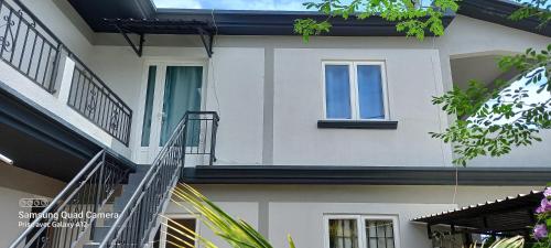a white building with a window and a staircase at Chez Mimi in Mahébourg