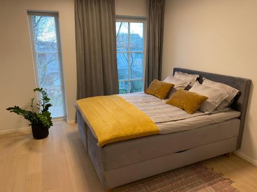 1 dormitorio con 1 cama con sábanas y almohadas amarillas en Modern Central Apartment HOTEL en Keyla