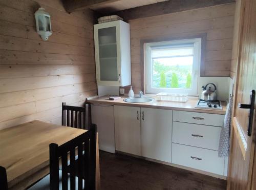 a kitchen with a sink and a window and a table at Domek BB in Podgórzyn