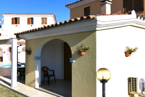 a house with an archway and a patio at Residence con piscina a Sos Alinos in Cala Liberotto