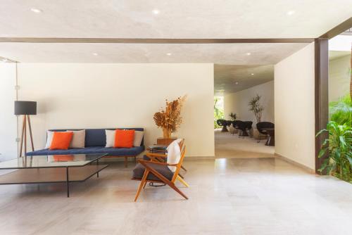 a living room with a blue couch and a glass table at Private pool and rooftop for 3 in Tulum