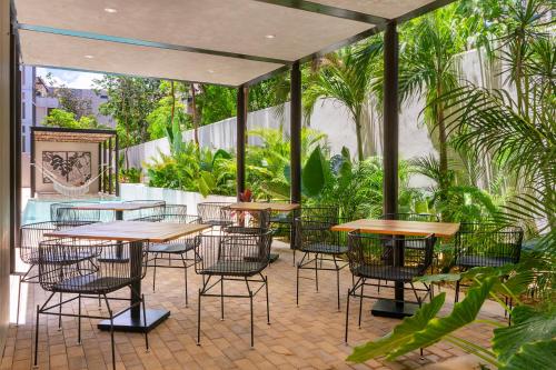 a patio with tables and chairs and plants at Private pool and rooftop for 3 in Tulum