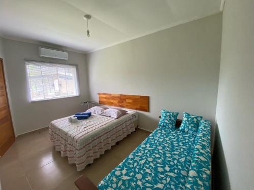 a bedroom with a bed and a couch in it at Pousada Ilha Sul in Cananéia