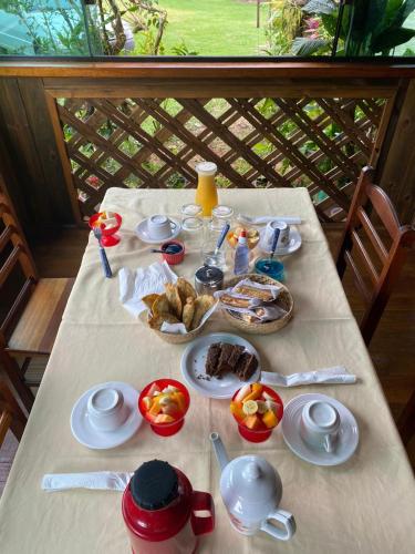 a table with food on it with a white table cloth at Pousada Ilha Sul in Cananéia
