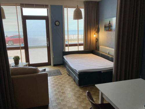 a bedroom with a bed and a couch and a window at Columbia in Ostend