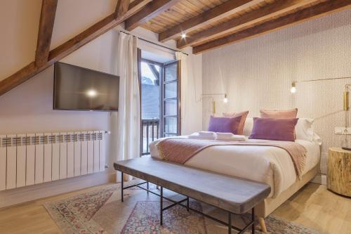 a bedroom with a large bed and a tv at Luderna - Casa Pleta de Arties Pruedo in Arties