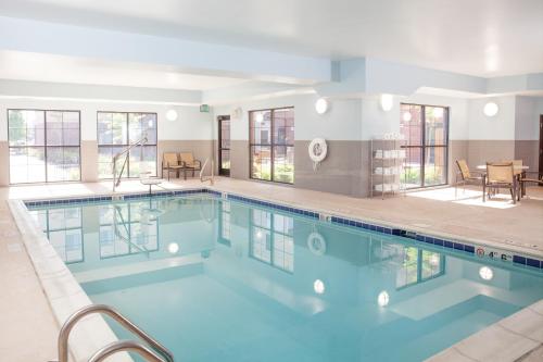 - une grande piscine d'eau bleue dans un bâtiment dans l'établissement Staybridge Suites Denver - Central Park, an IHG Hotel, à Denver