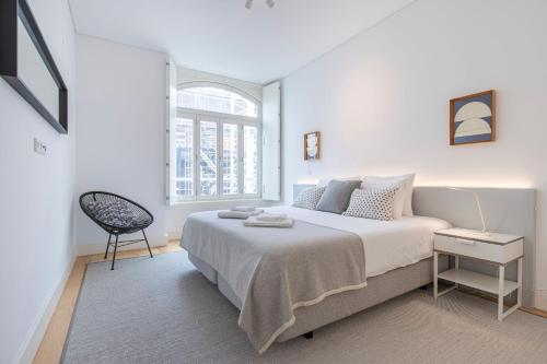 リスボンにあるModern Rustic Flat in Santos by LovelyStayの白いベッドルーム(大型ベッド1台、椅子付)