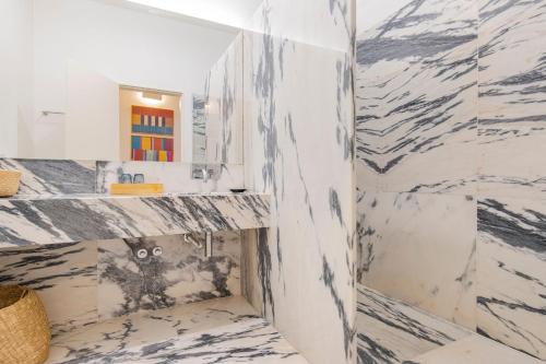 リスボンにあるModern Rustic Flat in Santos by LovelyStayの白い大理石の壁のバスルーム(シンク付)