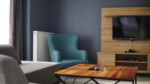 a living room with a tv and a chair and a coffee table at Centrum Residence in Ankara