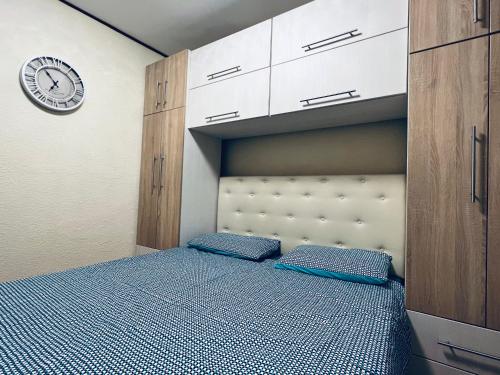 ein Schlafzimmer mit einem Bett und einer Uhr an der Wand in der Unterkunft Altheda Living Tineretului E8 in Suceava