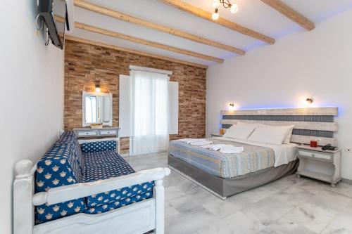 a bedroom with a large bed and a brick wall at Agios Prokopios Hotel in Agios Prokopios