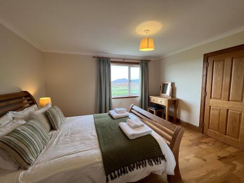 a bedroom with a large bed with a window at Airigh nam Fiadh in Clachan
