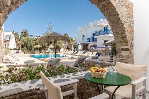 une terrasse avec une table, des chaises et une piscine dans l'établissement Agios Prokopios Hotel, à Ágios Prokópios