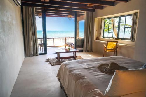 a bedroom with a bed and a view of the ocean at Amansala Resort in Tulum