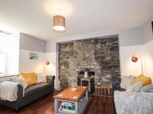 een woonkamer met een stenen muur en een open haard bij 2 Seafield Place in Portsoy