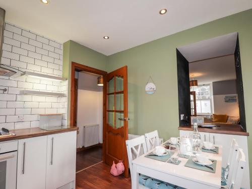 a kitchen with a table and chairs and a mirror at 2 Seafield Place in Portsoy