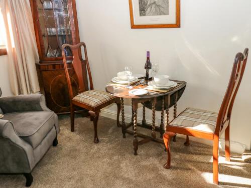 a dining room with a table and chairs and a bottle of wine at Prospect Cottage in Sowerby Bridge