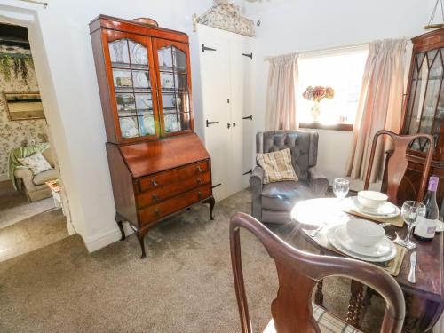 a dining room with a table and a china cabinet at Prospect Cottage in Sowerby Bridge