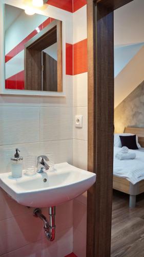 a bathroom with a sink and a bed at U Šípků in Ostrava