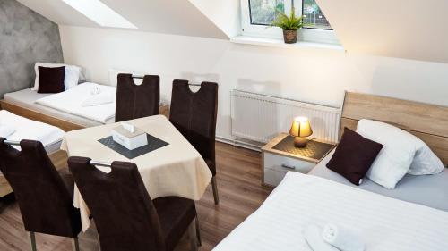 a room with two beds and a table and chairs at U Šípků in Ostrava