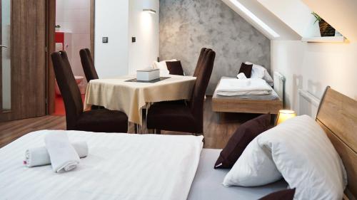 a room with two tables and a bed and chairs at U Šípků in Ostrava