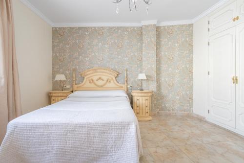 a bedroom with a bed and two night stands at Terraza Mar y Montaña in Nerja