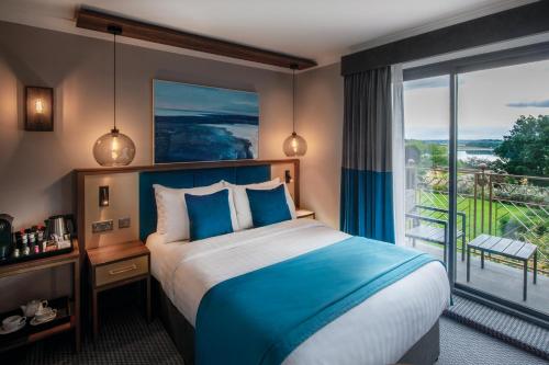 a hotel room with a bed and a large window at Rutland Hall Hotel in Oakham