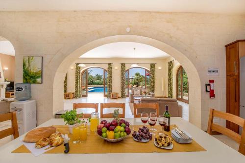 a kitchen with a table with a bowl of fruit at The Olives Holiday Home in San Lawrenz