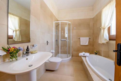 een badkamer met een wastafel, een toilet en een bad bij The Olives Holiday Home in San Lawrenz