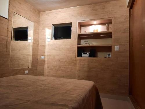 een slaapkamer met een bed en een tv aan de muur bij Shallor Cryss Polonia in San Miguel de Tucumán