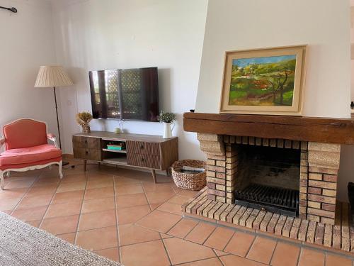 a living room with a fireplace and a red chair at House of Rising Sun in Quarteira