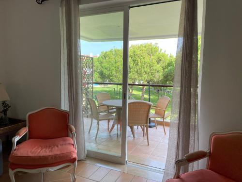 a room with a glass door leading to a patio with a table and chairs at House of Rising Sun in Quarteira