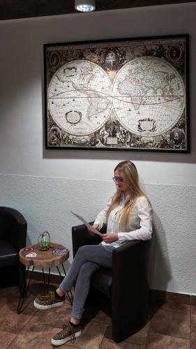 a woman sitting in a chair with a laptop at U Šípků in Ostrava