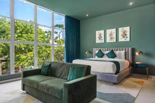 een slaapkamer met een bed, een bank en ramen bij Don Rafa Boutique Hotel & Residences in San Juan