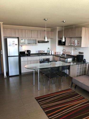 une cuisine avec une table et un réfrigérateur dans l'établissement Dpto tipo Resort, à Viña del Mar