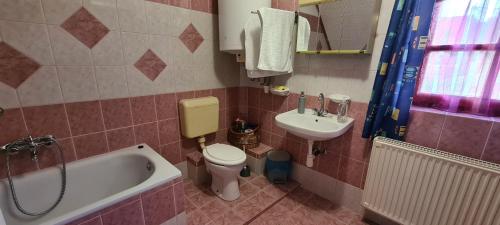 a bathroom with a tub and a toilet and a sink at Eszter-lak in Monostorapáti