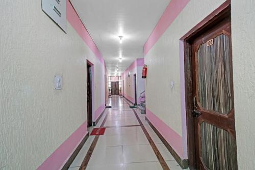 a hallway with pink and white walls and a door at Hotel grand City heart in Srinagar