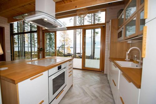 a kitchen with white appliances and a large window at Rantarovio in Alvajärvi