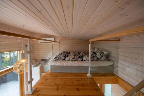 a bed in a room with a wooden ceiling at Rantarovio in Alvajärvi