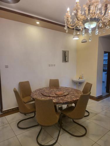a dining room table with chairs and a chandelier at Meshaal heights in Mombasa