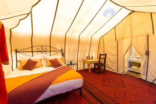 a bedroom with a bed in a tent at Luxury Bega Camp in Merzouga