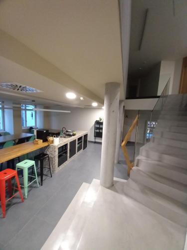 a large room with a staircase and a kitchen at LUMEN ALBERGUE in Mondoñedo