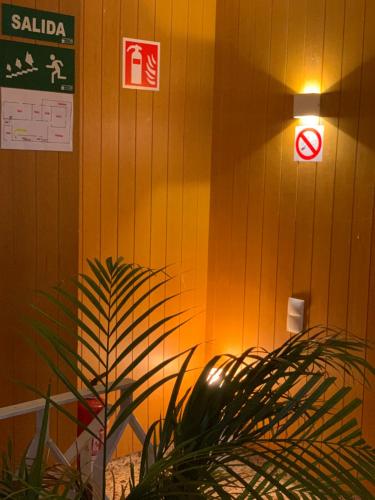 a light on a wall with a sign and a plant at Villa Entrenaranjos in Picassent